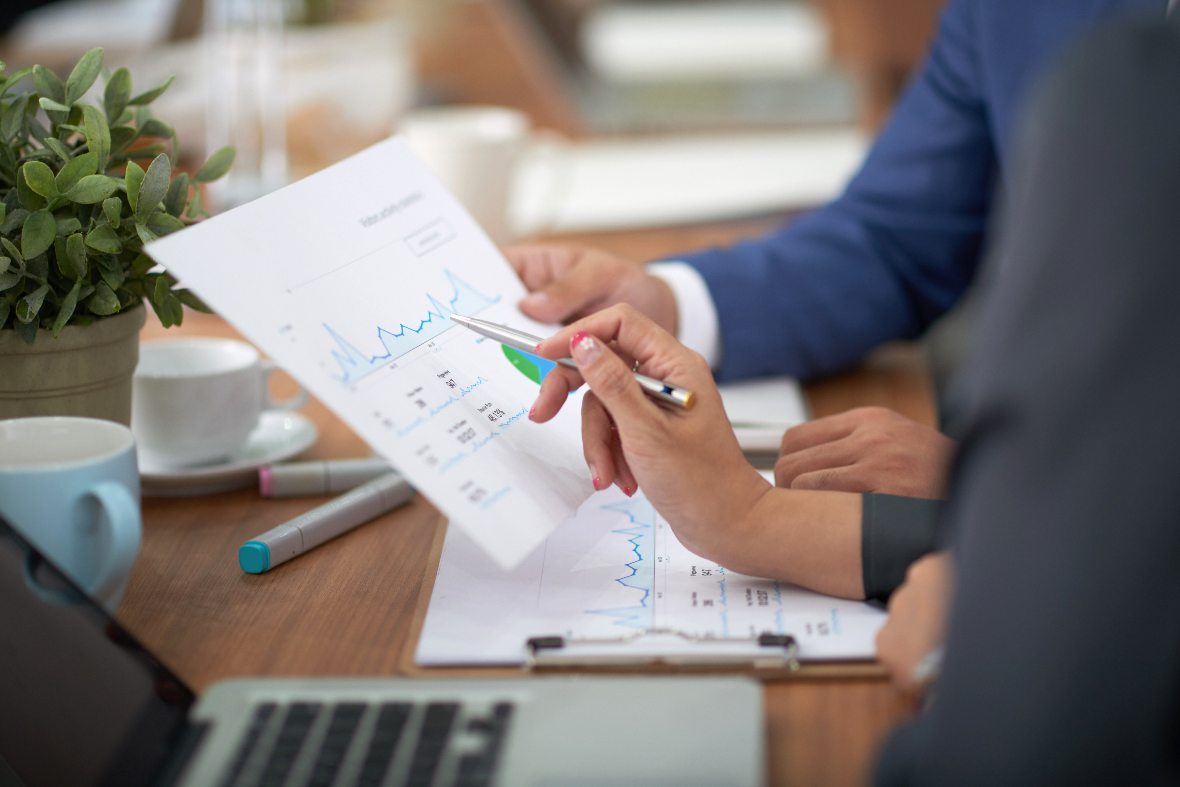 hands-man-woman-business-attire-sitting-desk-office-discussing-graph (1)